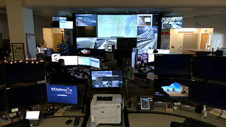 Staff at the Traffic Managemetn Center  (TMC)look at traffic cameras and maps on computer screens.