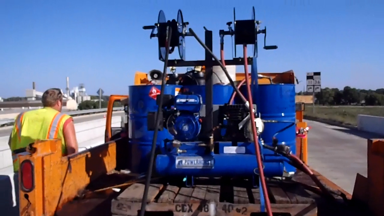 using blue tanks on an orange truck to seal bridge decks efficiently