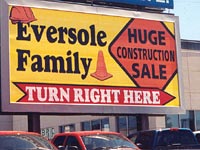Large yellow billboard, says "Eversole Family, Huge Construction Sale, Turn Right Here."