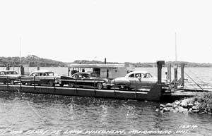 Black and white photo of the Merrimac Ferry, Colsac I, with cars about to unload.