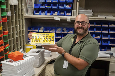 Male DMV staff with license plate