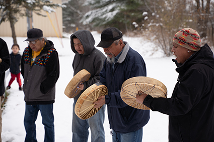Drumming circle at the recently installed dual langauge sign.