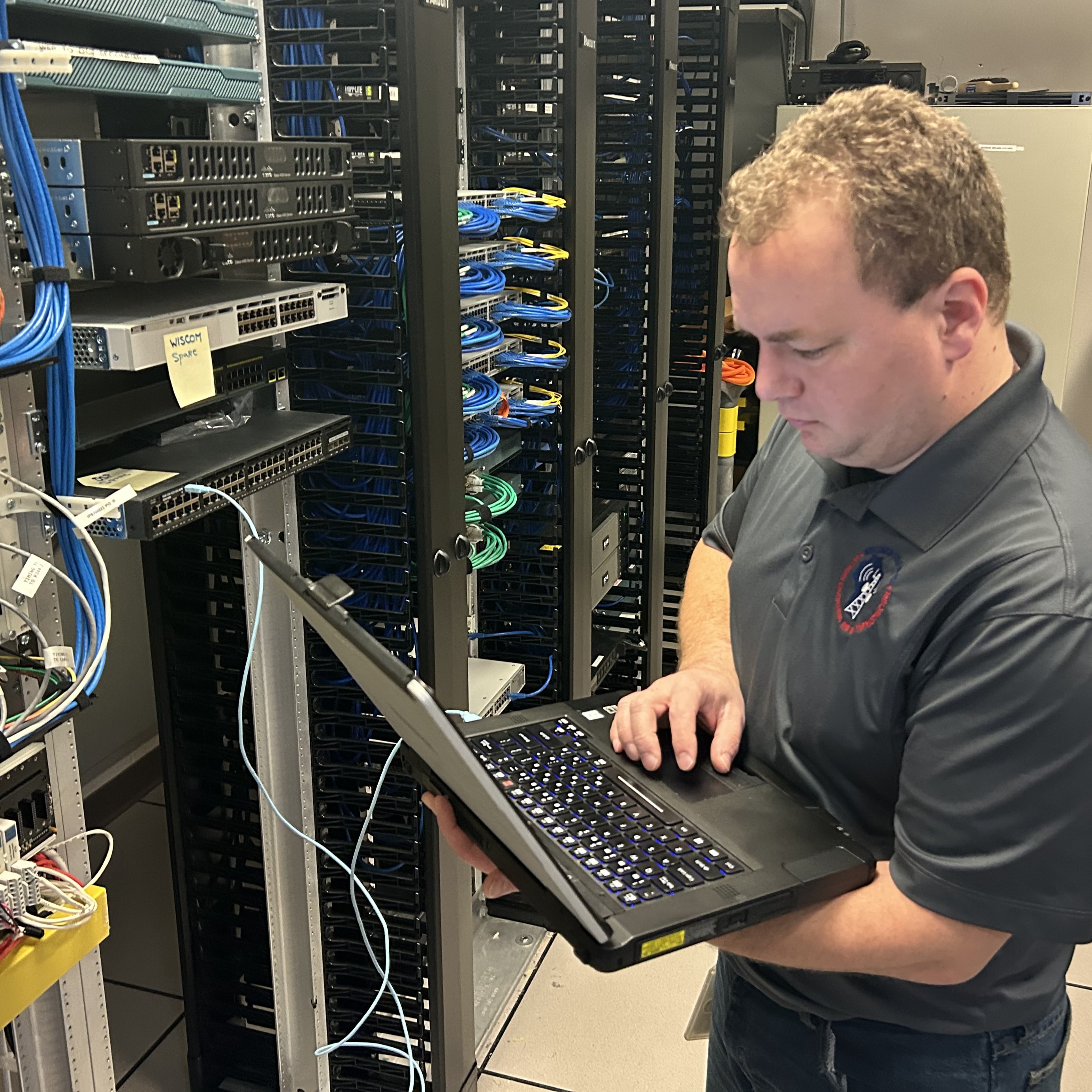 Wisconsin State Patrol networking staff working on computer near data equipment
