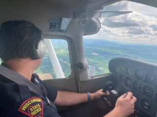 WSP pilot at the stick of a Cesna 172 looking out the left plane window