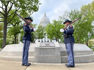Two State Patrol Honor Guard Unit officers facing one another in front of the Wisconsin Law Enforcement Memorial